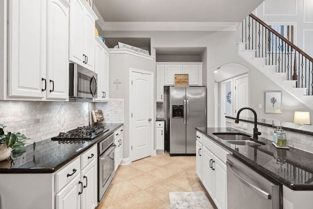 218 Sunrise Ridge Loop, Lakeway, TX 78738 - kitchen with appliances with stainless steel finishes, arched walkways, decorative backsplash, ornamental molding, and white cabinets