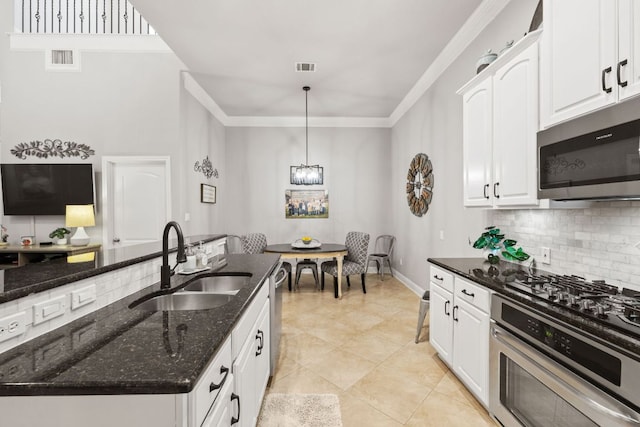 218 Sunrise Ridge Loop, Lakeway, TX 78738 - kitchen with appliances with stainless steel finishes, tasteful backsplash, white cabinets, dark stone countertops, and crown molding