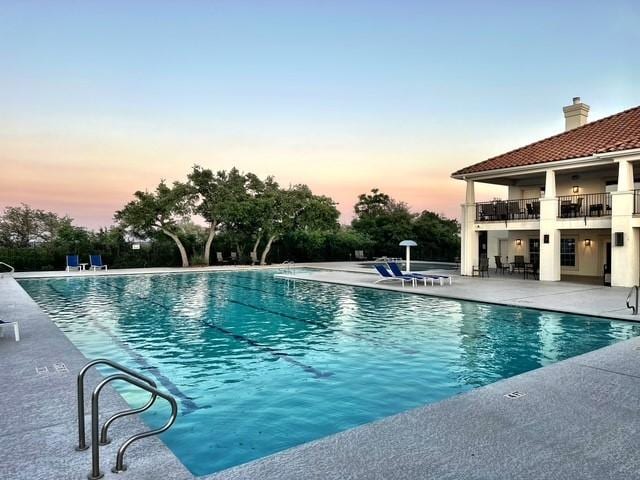 218 Sunrise Ridge Loop, Lakeway, TX 78738 - pool at dusk with a patio area and a community pool