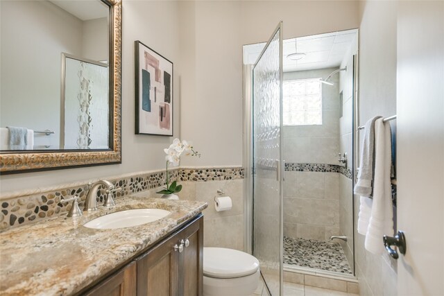 2305 Manana St, Austin, TX 78730 - bathroom with toilet, vanity, a stall shower, a wainscoted wall, and tile patterned floors
