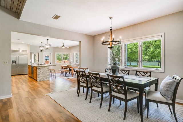 2305 Manana St, Austin, TX 78730 - dining space with a chandelier, light wood finished floors, a ceiling fan, and baseboards