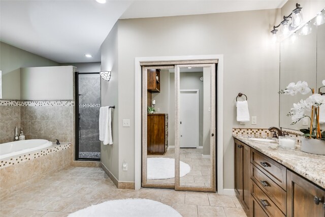 2305 Manana St, Austin, TX 78730 - bathroom with vanity, a garden tub, tile patterned flooring, a tile shower, and baseboards