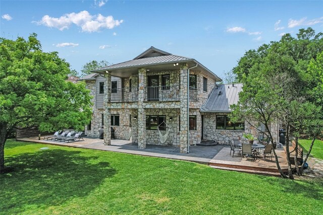 2305 Manana St, Austin, TX 78730 - back of house with a standing seam roof, a balcony, stone siding, and a patio area