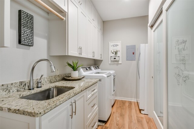 2305 Manana St, Austin, TX 78730 - washroom with washer and clothes dryer, electric panel, light wood-style floors, cabinet space, and baseboards