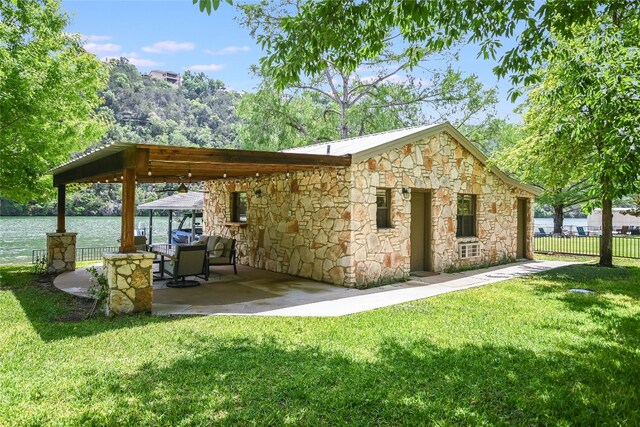 2305 Manana St, Austin, TX 78730 - back of house featuring stone siding, a patio, and a water view