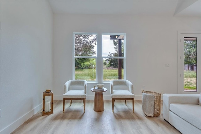 sitting room featuring baseboards and light wood finished floors