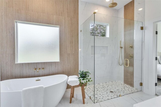 bathroom featuring a soaking tub, a marble finish shower, and marble finish floor