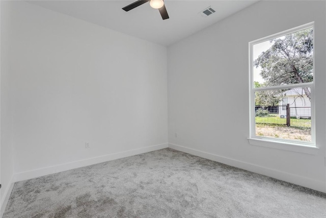 spare room with plenty of natural light, visible vents, carpet floors, and ceiling fan