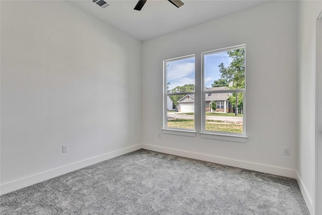 spare room with visible vents, carpet flooring, baseboards, and a ceiling fan