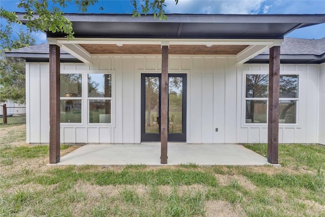 353 Nene Ln, Bastrop, TX 78602 - rear view of house with board and batten siding, a shingled roof, a patio, and a yard