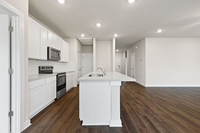 208 Lazy Lizzy Rd, Jarrell, TX 76537 - kitchen featuring stainless steel appliances, a kitchen island with sink, dark wood finished floors, white cabinets, and recessed lighting