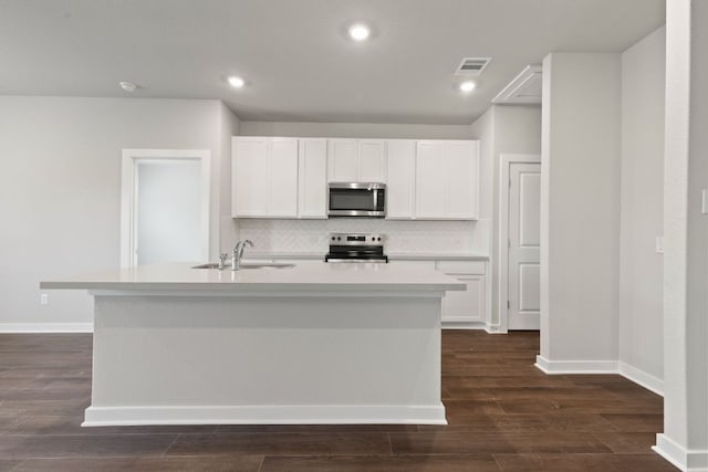 208 Lazy Lizzy Rd, Jarrell, TX 76537 - kitchen with stainless steel appliances, decorative backsplash, white cabinets, a center island with sink, and light countertops