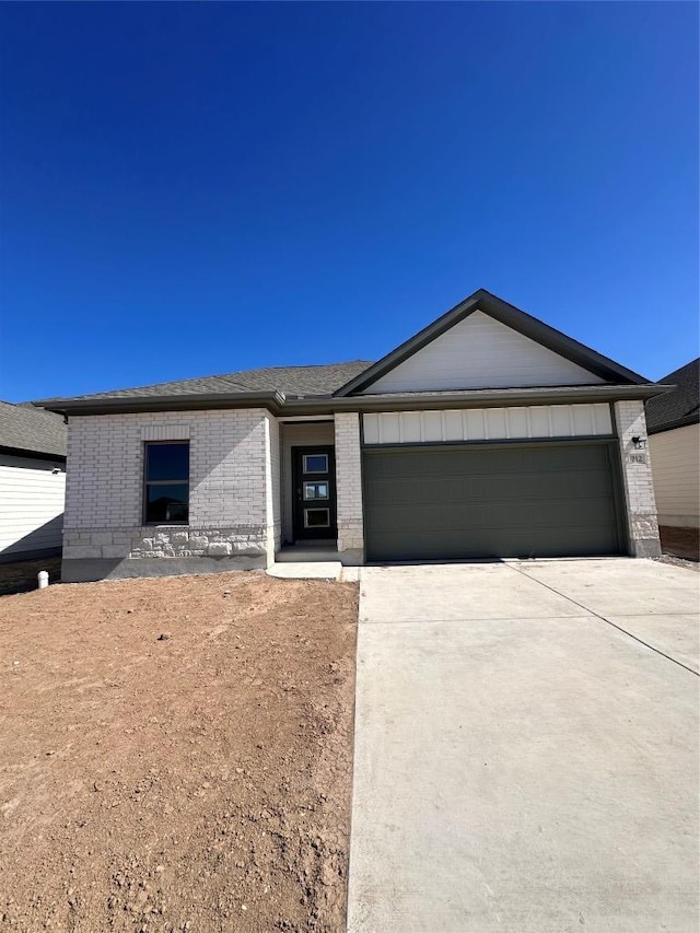 view of front of home featuring brick siding, driveway, and a garage