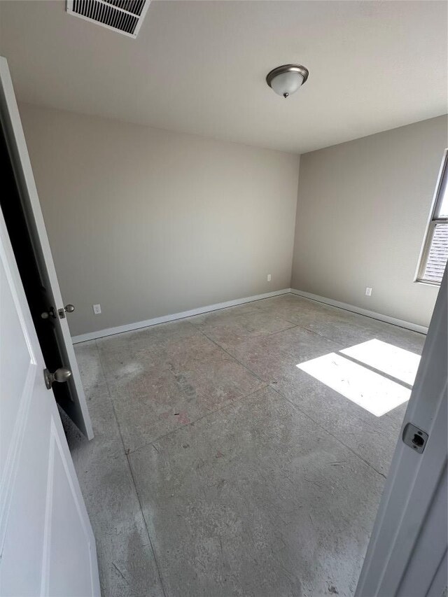 spare room featuring baseboards and visible vents