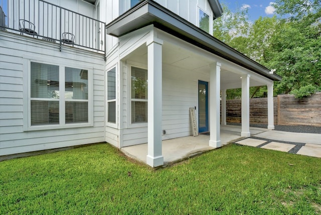 exterior space featuring a lawn, fence, a patio area, and board and batten siding