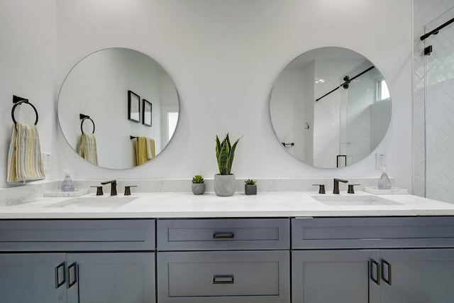 bathroom with a shower, a sink, and double vanity