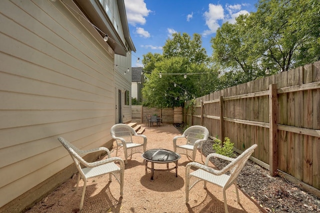 view of patio featuring a fire pit and fence