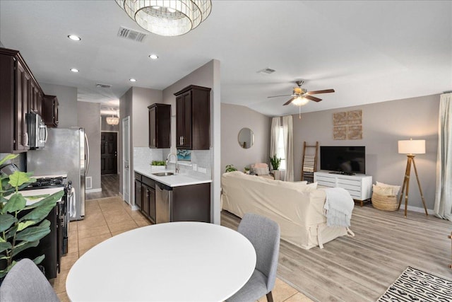 kitchen with light countertops, visible vents, a sink, dark brown cabinetry, and appliances with stainless steel finishes