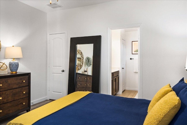 bedroom featuring visible vents, baseboards, and connected bathroom