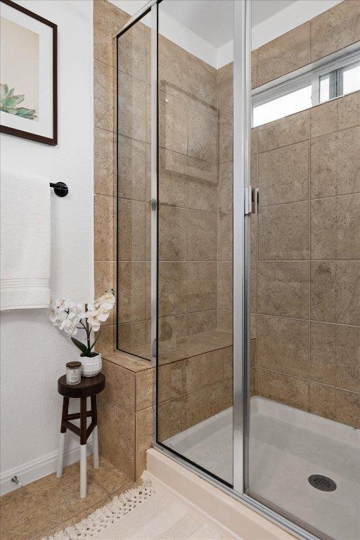bathroom with baseboards and a stall shower