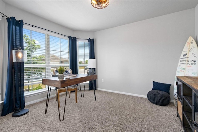 carpeted home office featuring baseboards