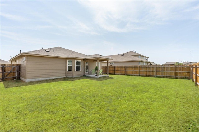rear view of property featuring a lawn, a patio, and a fenced backyard