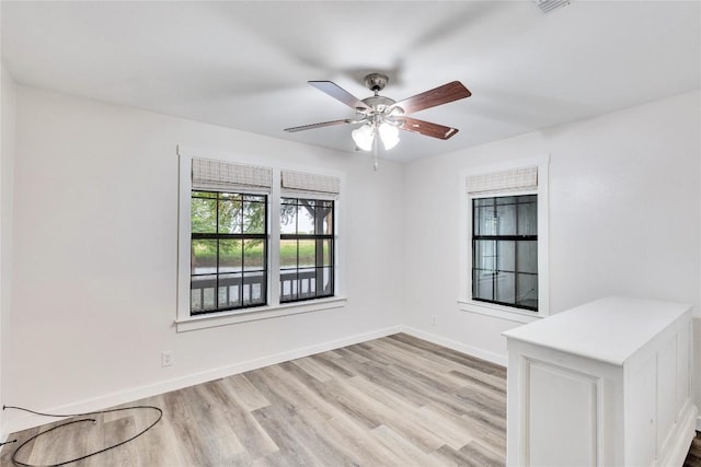 unfurnished room featuring light wood-style flooring, baseboards, and ceiling fan