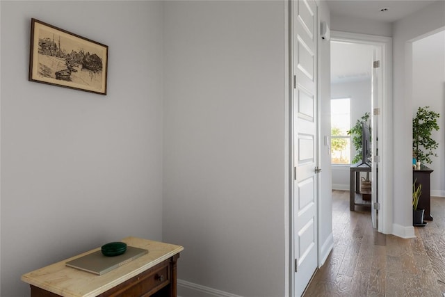 corridor with baseboards and dark wood-style floors