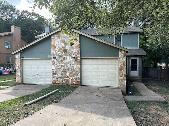 view of front of home featuring concrete driveway, stone siding, entry steps, and a garage