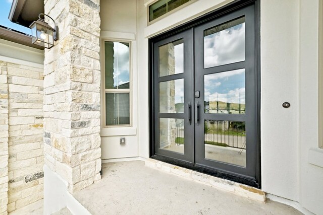 905 Crestone Stream Dr, Austin, TX 78738 - view of exterior entry with french doors and stone siding
