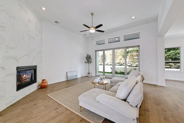 905 Crestone Stream Dr, Austin, TX 78738 - living area with wood finished floors, recessed lighting, a ceiling fan, a fireplace, and a towering ceiling