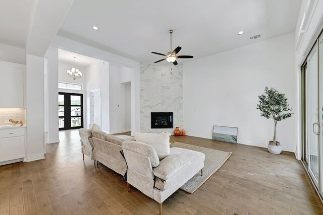 905 Crestone Stream Dr, Austin, TX 78738 - living area featuring wood finished floors, ceiling fan, recessed lighting, a premium fireplace, and a chandelier