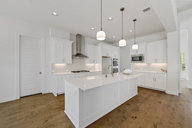905 Crestone Stream Dr, Austin, TX 78738 - kitchen with wall chimney exhaust hood, stainless steel appliances, wood finished floors, decorative backsplash, and recessed lighting