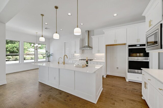 905 Crestone Stream Dr, Austin, TX 78738 - kitchen with stainless steel appliances, wall chimney range hood, recessed lighting, white cabinetry, and light countertops