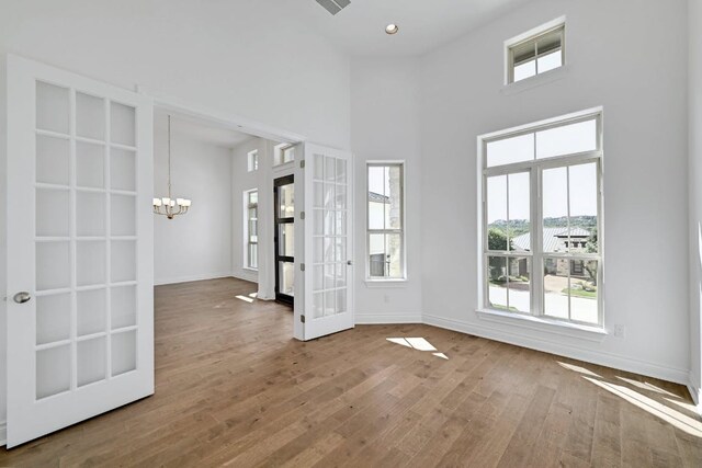 905 Crestone Stream Dr, Austin, TX 78738 - spare room with a chandelier, plenty of natural light, wood finished floors, french doors, and a high ceiling