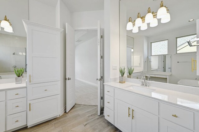 905 Crestone Stream Dr, Austin, TX 78738 - bathroom with a tile shower, wood finished floors, and two vanities