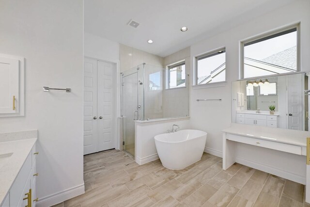 905 Crestone Stream Dr, Austin, TX 78738 - full bath with a shower stall, two vanities, a soaking tub, wood tiled floors, and recessed lighting