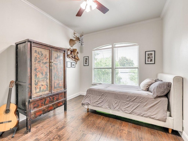 bedroom featuring baseboards, a ceiling fan, wood finished floors, and ornamental molding