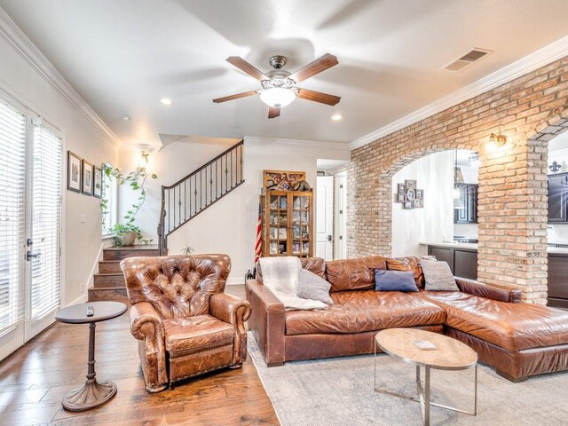 1202 S Flores St Unit 102, San Antonio, TX 78204 - living area with stairway, ceiling fan, brick wall, wood finished floors, and crown molding