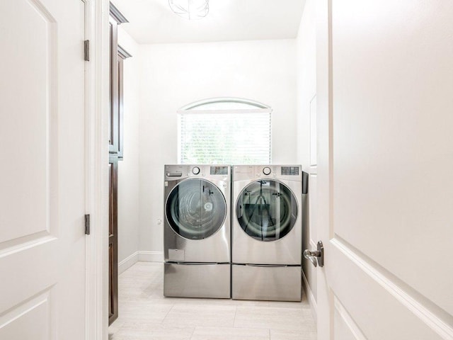 clothes washing area with washing machine and clothes dryer and laundry area