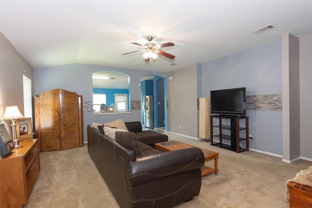 114 Mossy Rock Cv, Hutto, TX 78634 - living area featuring light colored carpet, ceiling fan, arched walkways, and vaulted ceiling