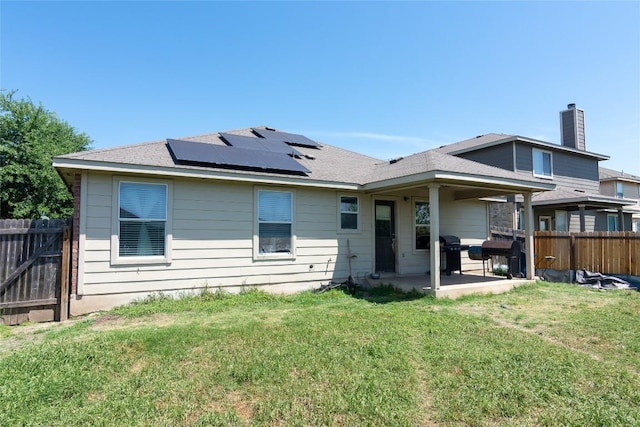 114 Mossy Rock Cv, Hutto, TX 78634 - rear view of property with a patio, solar panels, a fenced backyard, a chimney, and a shingled roof