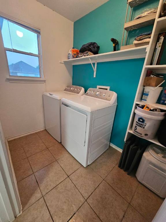 114 Mossy Rock Cv, Hutto, TX 78634 - laundry area with washing machine and dryer and light tile patterned floors