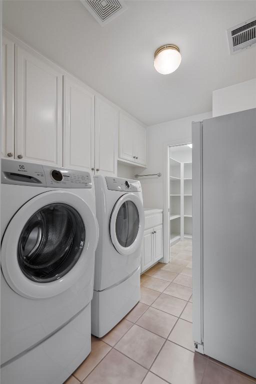 4602 Laurel Canyon Dr, Austin, TX 78731 - laundry area featuring separate washer and dryer, cabinet space, and light tile patterned floors