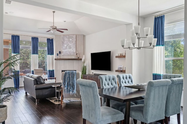 3905 Veneto Cir, Leander, TX 78641 - dining room with a chandelier, dark wood-type flooring, a ceiling fan, and a tiled fireplace