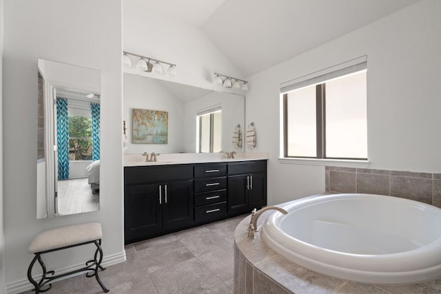 3905 Veneto Cir, Leander, TX 78641 - bathroom featuring tiled bath, vaulted ceiling, and double vanity
