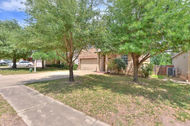 obstructed view of property with fence, central air condition unit, concrete driveway, an attached garage, and a front yard