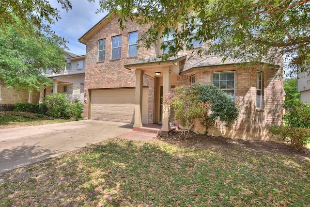 traditional-style home featuring concrete driveway, an attached garage, and brick siding
