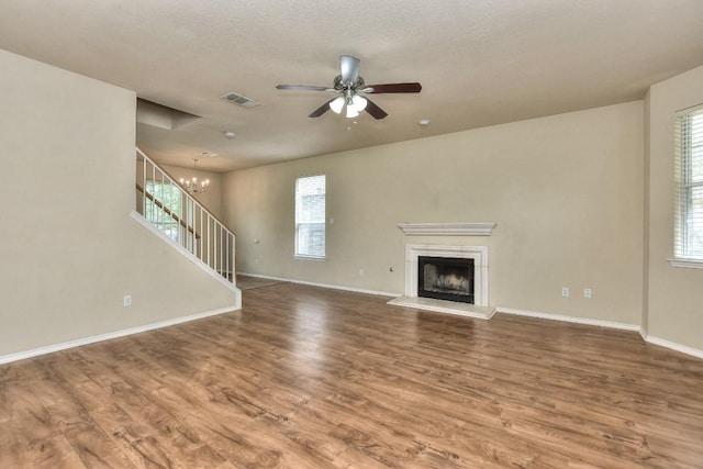 2625 Summerwalk Pl, Round Rock, TX 78665 - unfurnished living room with ceiling fan, plenty of natural light, a chandelier, and wood finished floors