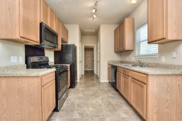 kitchen with a sink, black appliances, light brown cabinetry, light countertops, and visible vents